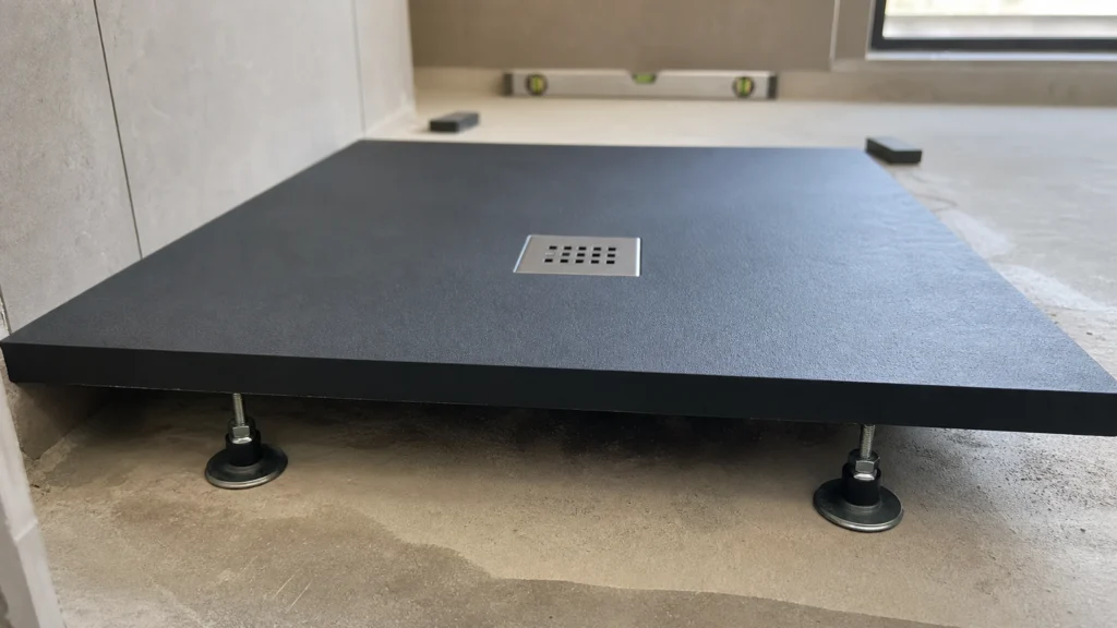 Receveur de douche noir mat avec grille carrée et pieds réglables avant installation