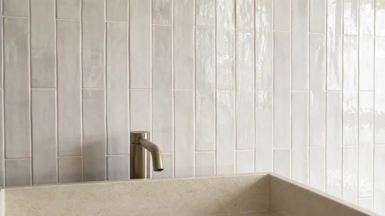 Mur de salle de bains en carrelage blanc brillant effet zellige au format 6 × 24 cm